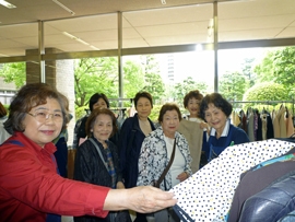 市役所を訪れた市民にバザー品をすすめるＳＩ岡山会長と岡山桃会長