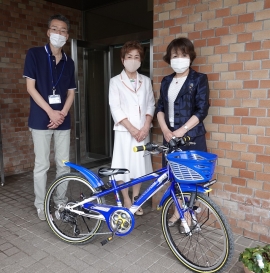 善隣館玄関前で自転車の贈呈品前で岩井館長・竹本会長・垪和副会長